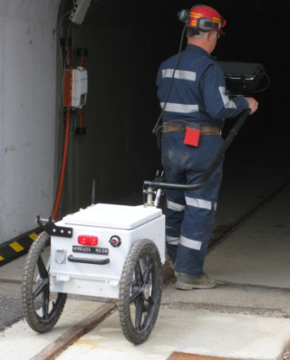 Joe Sabo wheels the MineComms Mapper cart into the main portal at the Bruceton Safety Research Mine. The tablet computer is mounted on the pull-bar.
